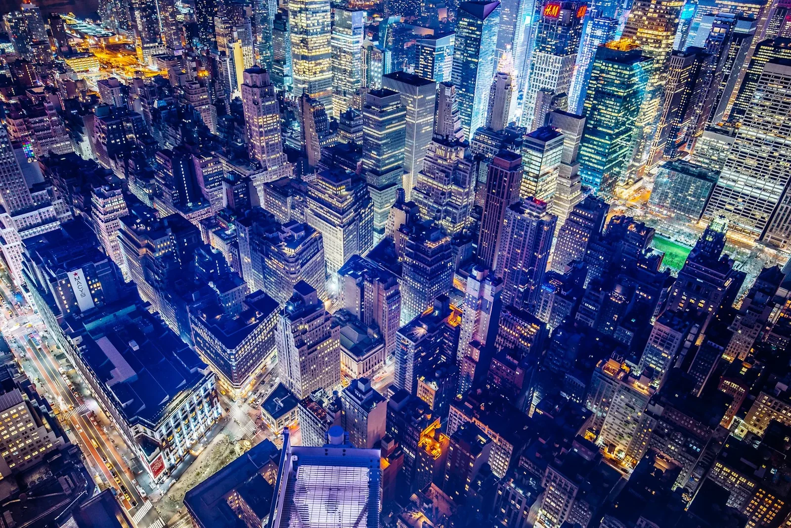 An elevated view of illuminated Manhattan buildings and streets at night